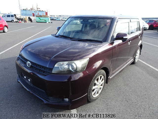 A grey JDM sports car speeding down a highway at night.