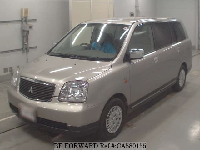 A grey JDM sports car speeding down a highway at night.
