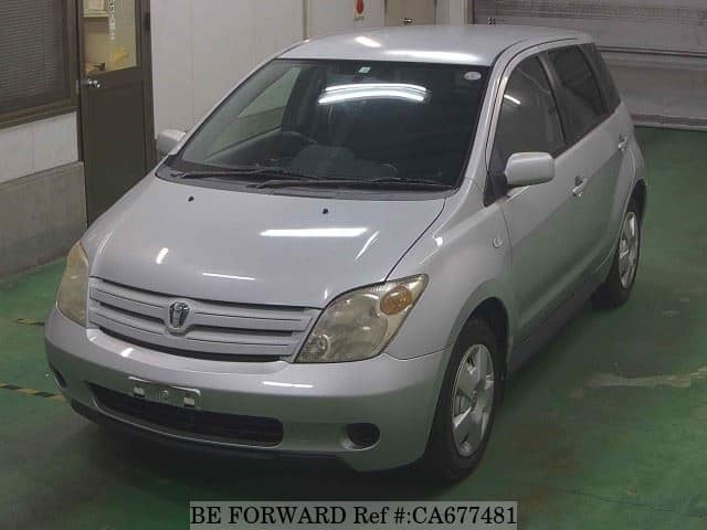 A grey JDM sports car speeding down a highway at night.
