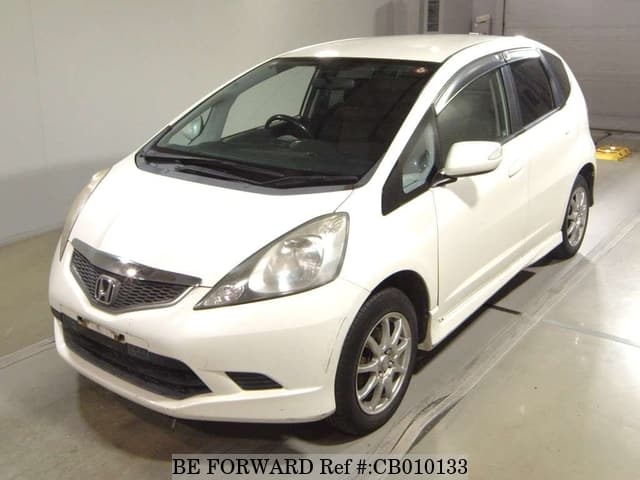 A grey JDM sports car speeding down a highway at night.