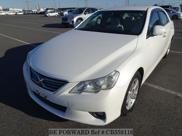 A grey JDM sports car speeding down a highway at night.