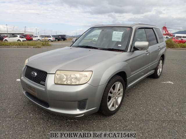A grey JDM sports car speeding down a highway at night.