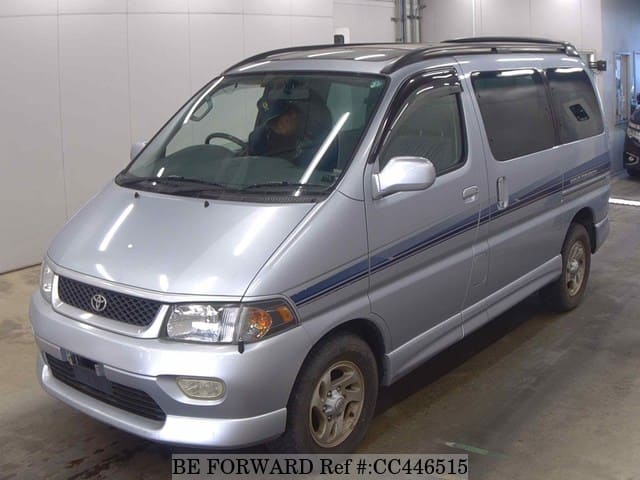 A grey JDM sports car speeding down a highway at night.