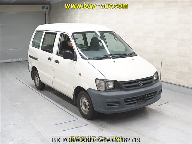 A grey sports car speeding down a highway at night.