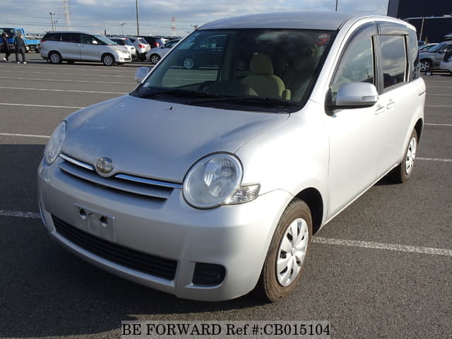 A grey JDM sports car speeding down a highway at night.