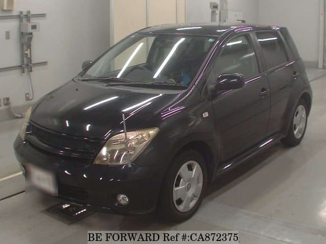 A grey JDM sports car speeding down a highway at night.