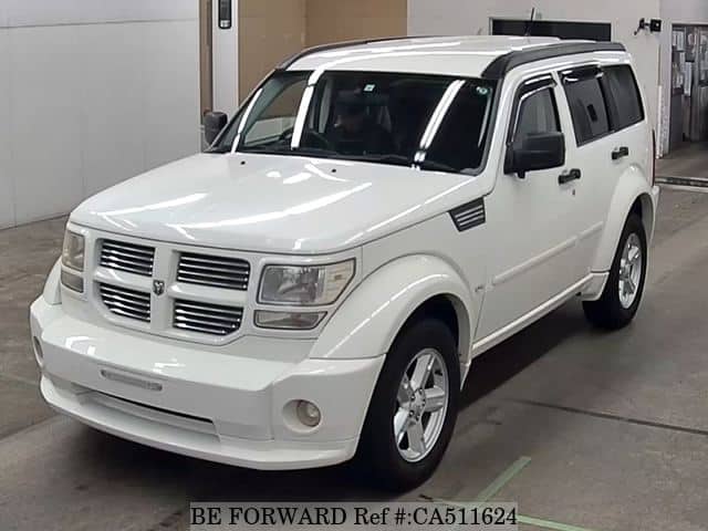A grey JDM sports car speeding down a highway at night.