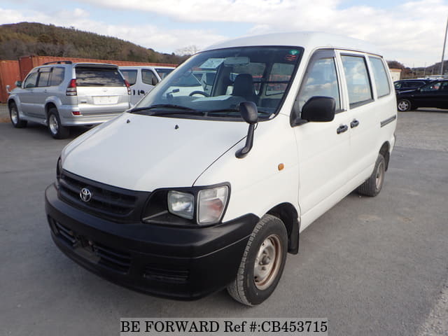A grey JDM sports car speeding down a highway at night.