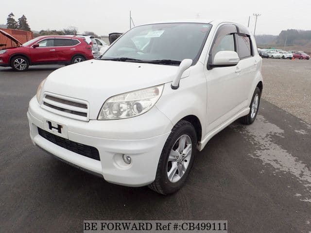 A grey JDM sports car speeding down a highway at night.