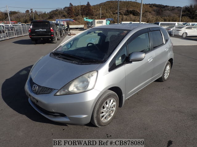 A grey JDM sports car speeding down a highway at night.