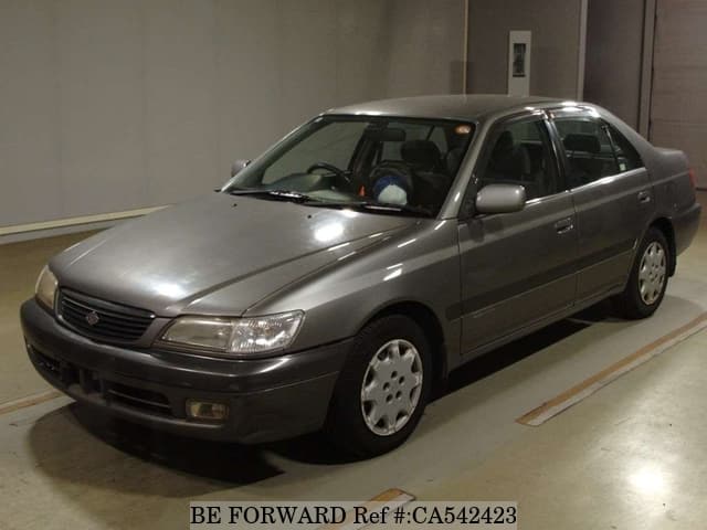 A grey JDM sports car speeding down a highway at night.
