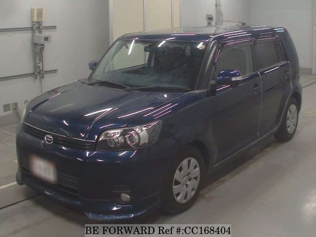 A grey sports car speeding down a highway at night.