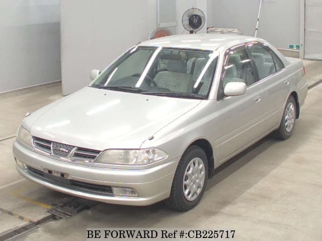 A grey JDM sports car speeding down a highway at night.