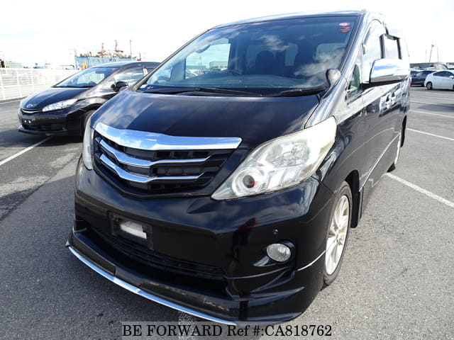 A grey JDM sports car speeding down a highway at night.