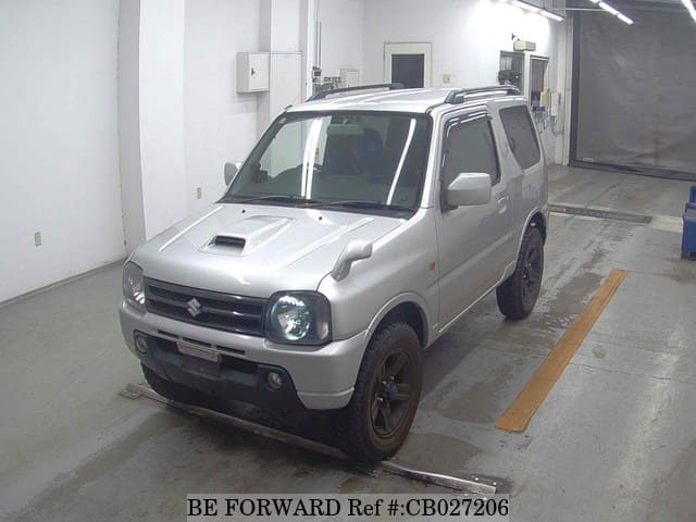 A grey JDM sports car speeding down a highway at night.