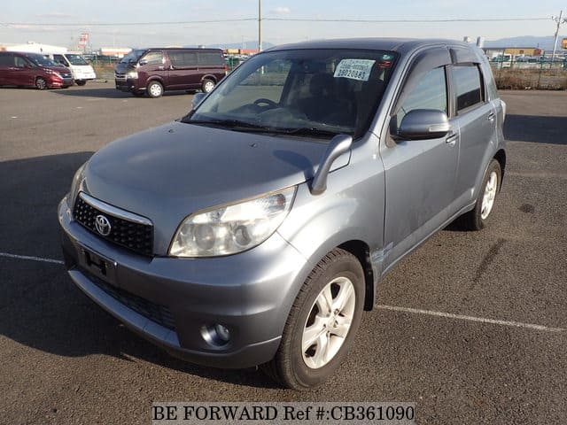 A grey JDM sports car speeding down a highway at night.