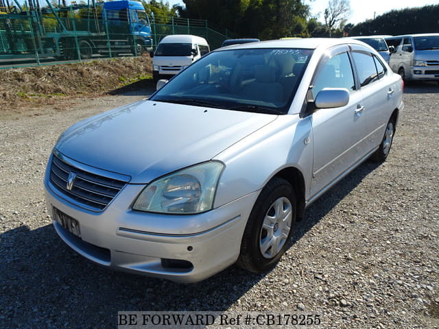 A grey sports car speeding down a highway at night.