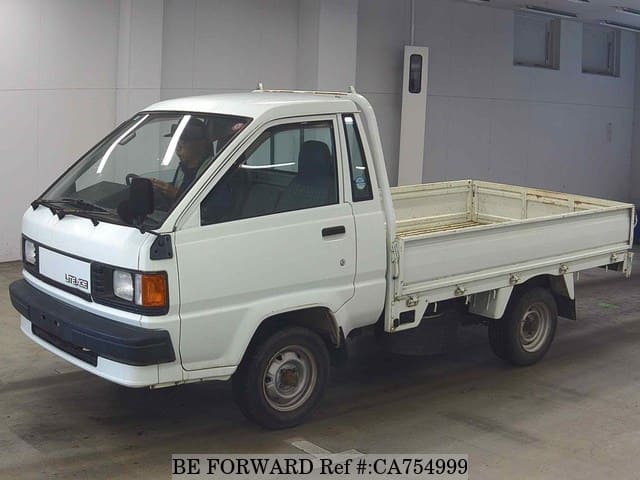 A grey JDM sports car speeding down a highway at night.