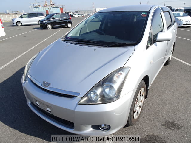A grey JDM sports car speeding down a highway at night.