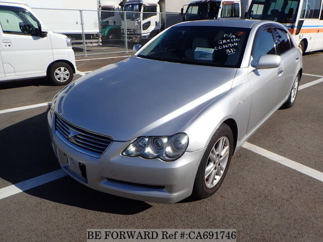 A grey JDM sports car speeding down a highway at night.