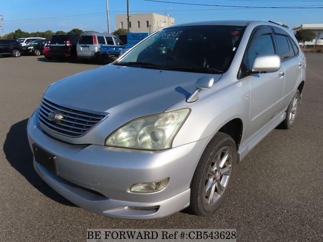 A grey sports car speeding down a highway at night.
