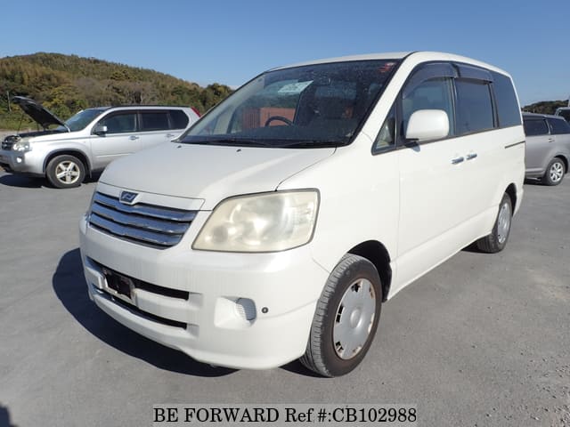 A grey JDM sports car speeding down a highway at night.