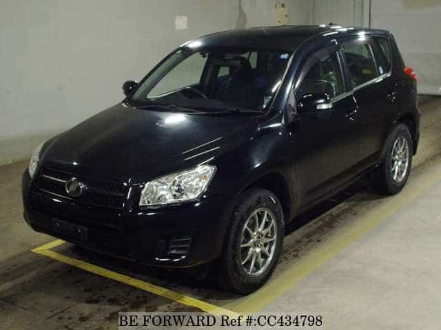 A grey JDM sports car speeding down a highway at night.