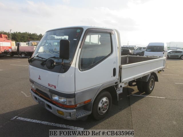 A grey JDM sports car speeding down a highway at night.