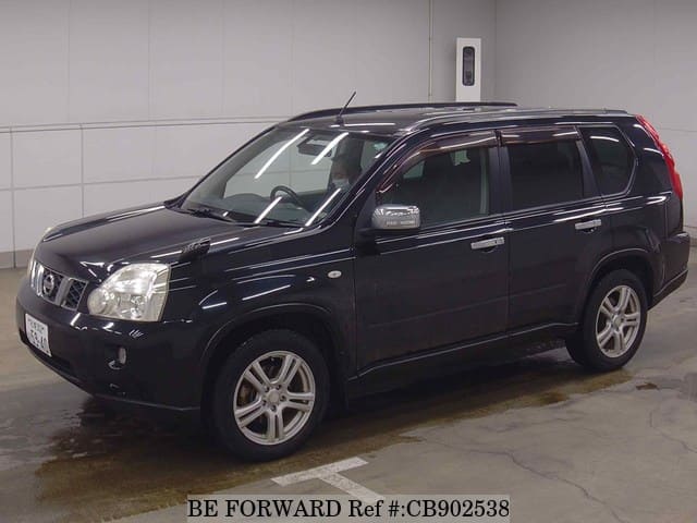 A grey sports car speeding down a highway at night.
