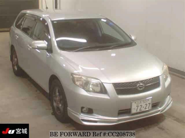 A grey sports car speeding down a highway at night.