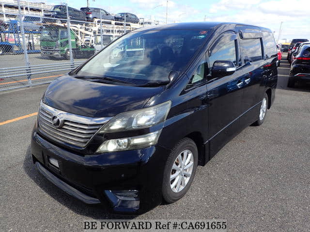 A grey JDM sports car speeding down a highway at night.