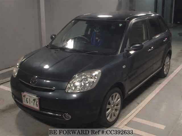 A grey sports car speeding down a highway at night.
