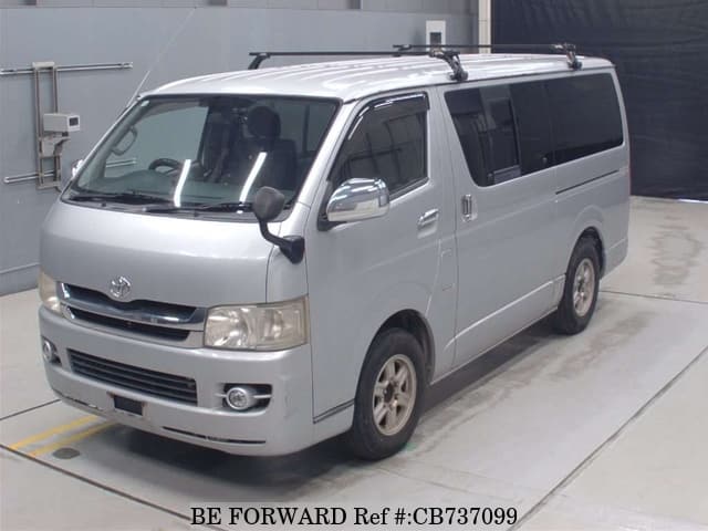 A grey JDM sports car speeding down a highway at night.
