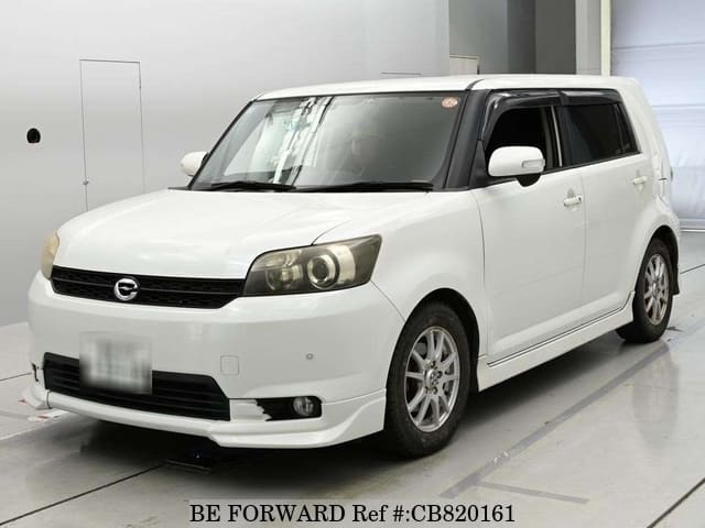 A grey JDM sports car speeding down a highway at night.