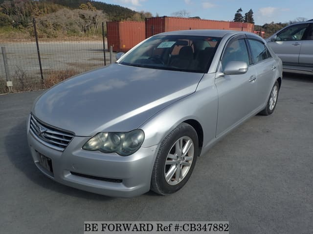 A grey JDM sports car speeding down a highway at night.