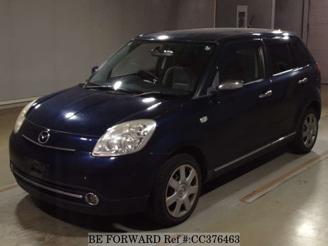 A grey sports car speeding down a highway at night.