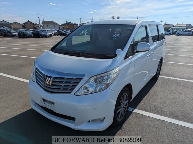 A grey sports car speeding down a highway at night.