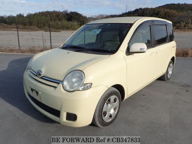 A grey JDM sports car speeding down a highway at night.
