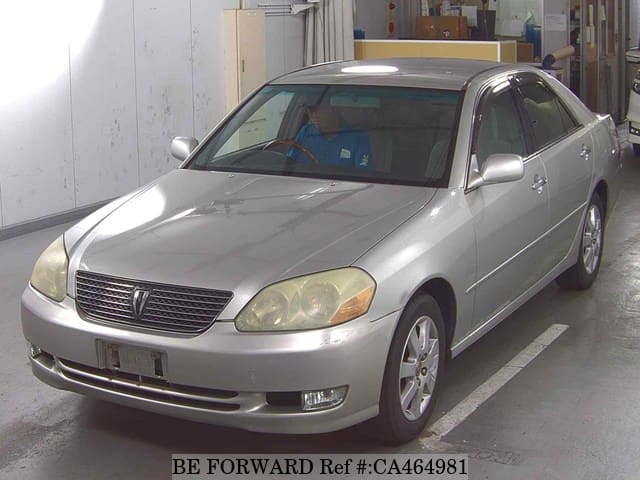 A grey JDM sports car speeding down a highway at night.
