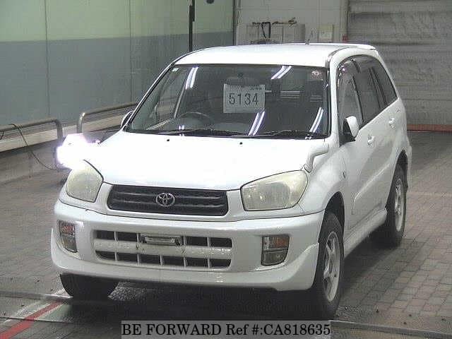 A grey JDM sports car speeding down a highway at night.