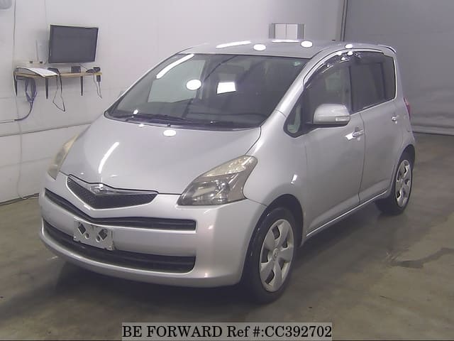 A grey sports car speeding down a highway at night.