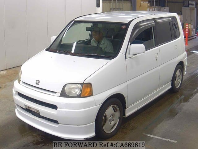 A grey JDM sports car speeding down a highway at night.