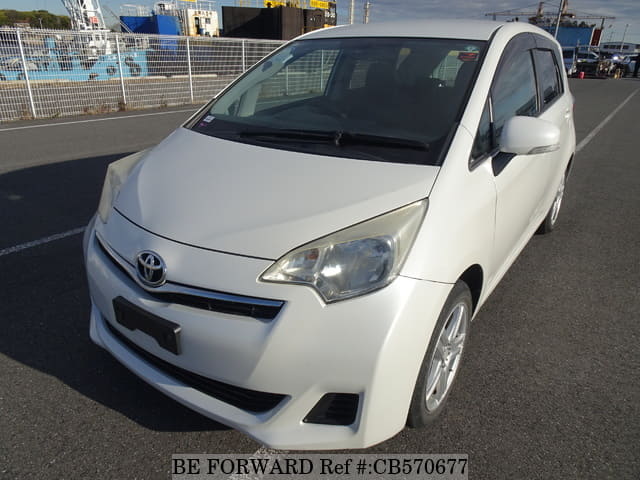 A grey JDM sports car speeding down a highway at night.