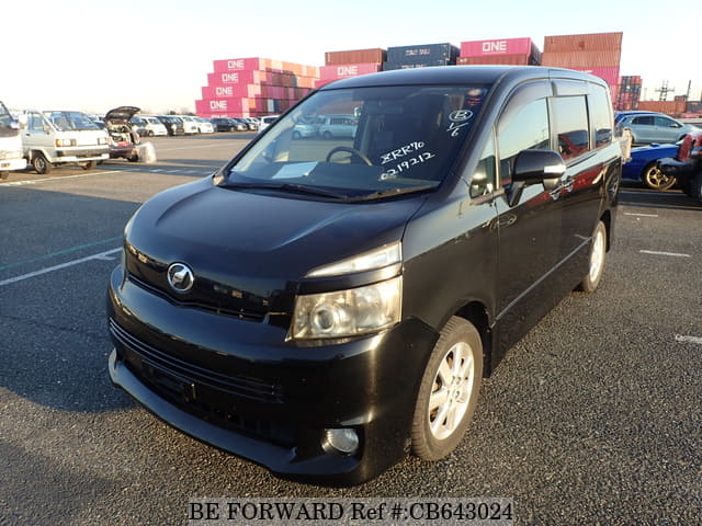 A grey sports car speeding down a highway at night.