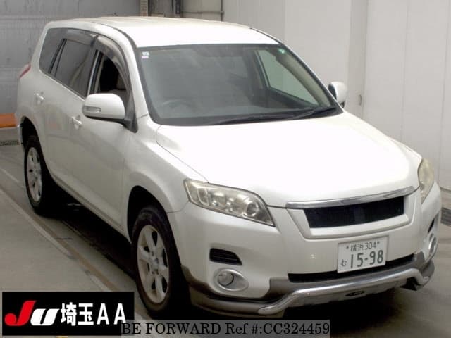 A grey sports car speeding down a highway at night.