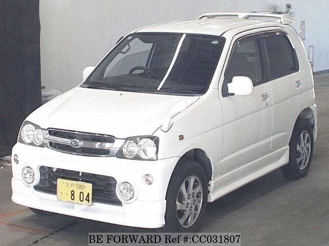 A grey sports car speeding down a highway at night.
