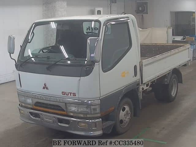 A grey sports car speeding down a highway at night.