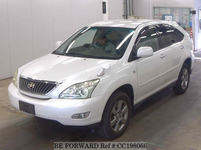 A grey sports car speeding down a highway at night.