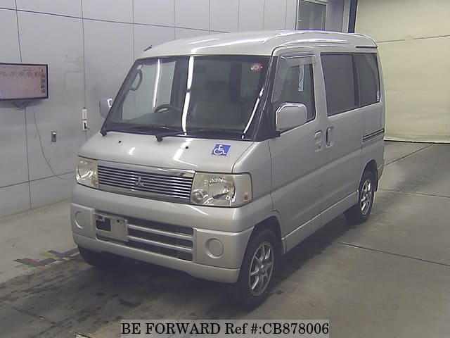 A grey JDM sports car speeding down a highway at night.