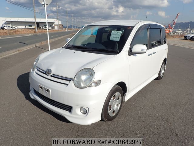 A grey JDM sports car speeding down a highway at night.